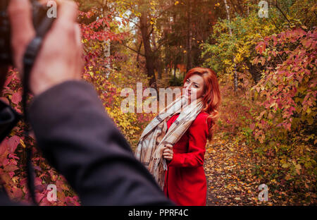 Der Mensch nimmt ein Bild von seiner Freundin tanzen im Herbst Wald Stockfoto