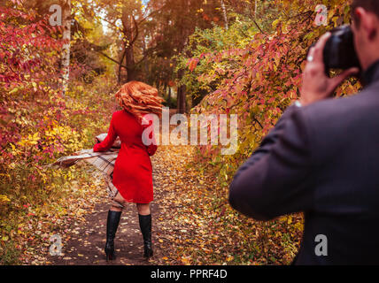 Der Mensch nimmt ein Bild von seiner Freundin spinnen mit der Kamera im Herbst Wald Stockfoto