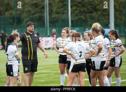 Eine Gruppe von Spielern der Frauen Rugby hören auf ihre Trainer talk Team Taktik während der Hälfte der Zeit brechen zu einem Rugby-spiel. Stockfoto