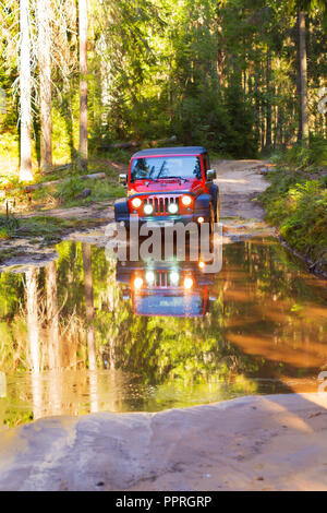 St. Petersburg, Russland - 2013 Juli 30 - Jeep Wrangler Rubicon Überqueren einer großen und tiefen Pfütze im Wald Stockfoto