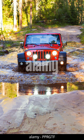 St. Petersburg, Russland - 2013 Juli 30 - Jeep Wrangler Rubicon Überqueren einer großen und tiefen Pfütze im Wald Stockfoto