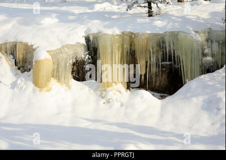 Eiszapfen hängen von einer Felswand. Verschneite Landschaft im Koli Nationalpark, Finnland Stockfoto