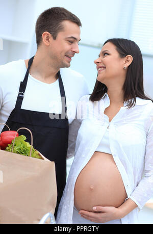 Mann und seine schwangere Frau sind Kämmen durch die Pack, stehen in der Küche Stockfoto