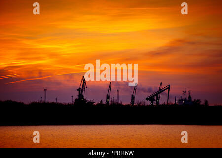 Blick auf den Seehafen mit Krane bei Sonnenuntergang. Abend Panorama der Cargo port Stockfoto