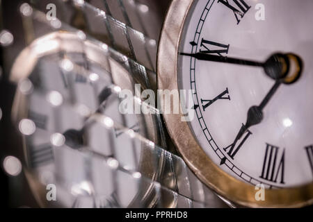 Close up arty Schuß eines Metall große Taschenuhr Uhr neben einem Silber Disco ball Stockfoto