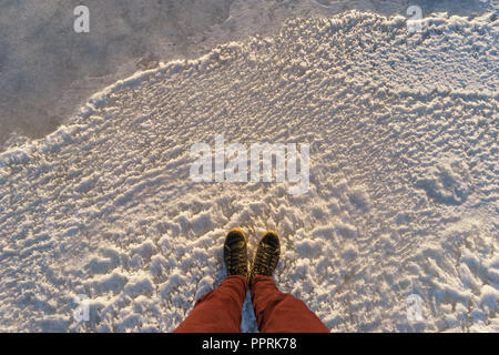 Männliche Läufe stehen auf eisigen Oberfläche, POV-shot Stockfoto