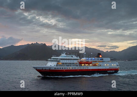 Die Hurtigruten Fähre, MS FINNMARKEN, Segeln Richtung Süden von Svolvær. Die Dramatischen Berge Der Lofoten-Inseln & Die Mitternachtssonne Hinter Norwegen. Stockfoto