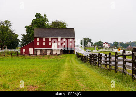 Bauernhäuser, Zäune und rote Ställe dot die Landschaft im historischen Gettysburg National Military Park. Stockfoto