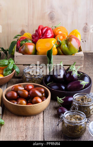 Bunte Gemüse auf ländlichen Holztisch, frische organische Landwirt Paprika, Auberginen und Tomaten, im Herbst die Zeit der Ernte noch Leben Stockfoto