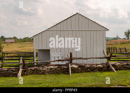 Eine weiße Scheune durch hölzerne Fechten an einem historischen Schlachtfeld von Gettysburg umgeben. Stockfoto