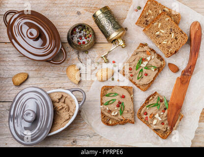 Frische hausgemachte Geflügel (Enten, Gänse, Kaninchen, Truthahn) Leber Pastete mit Mandeln, rosa Pfeffer und grüne Zwiebeln auf Vollkornbrot mit Samen. Tradition Stockfoto
