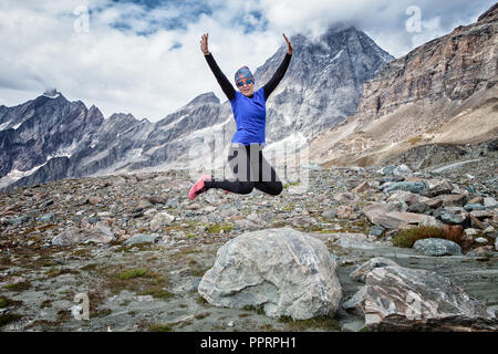 Frau Sprung von einem Felsen in die italienischen Berge Alpen Stockfoto