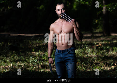 Wolverine mit Krallen ständigen starken Natur- und Biegungsspiel Muskeln - athletische Superhelden Posing Stockfoto