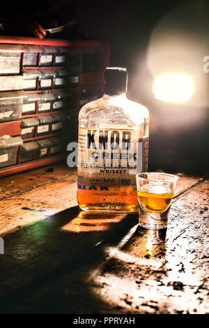 Eine Flasche Knob Creek sitzt auf einer Werkbank in einem Shop. Es ist wahrscheinlich nicht nur in der Betriebsart nach Geschäftsschluss schlagen... Stockfoto