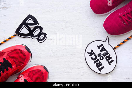 Happy Halloween Tag. Männliche und weibliche Sport Schuhe mit Trick oder Festlichkeit Wort und buh Wort. Halloween männlichen und weiblichen lustig und Shopping Konzept. Stockfoto