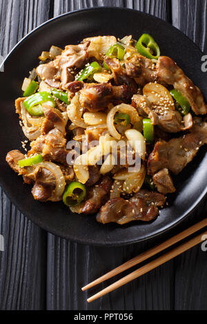 Traditionelle koreanische spicy Chicken gizzard mit Zwiebeln, Knoblauch, Chili und Sesam close-up auf den Tisch. Vertikal oben Ansicht von oben Stockfoto