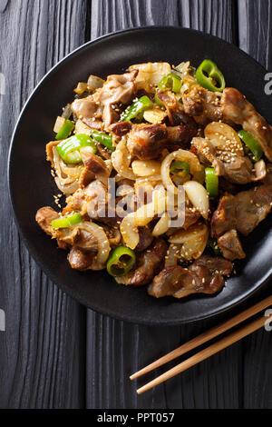 Dak-ttongjip ist eine koreanische Gericht durch Rühren, Braten Huhn gizzard mit Gewürzen close-up auf einem Teller auf dem Tisch. Vertikal oben Ansicht von oben Stockfoto