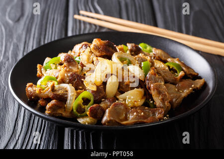 Koreanische Fried Chicken gizzard mit jalapeno Pfeffer, Zwiebel, Knoblauch und Sesam close-up auf einem Teller auf den Tisch. Horizontale Stockfoto