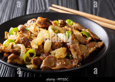 Traditionelle koreanische spicy Chicken gizzard mit Zwiebeln, Knoblauch, Chili und Sesam close-up auf dem Tisch. Horizontale Stockfoto