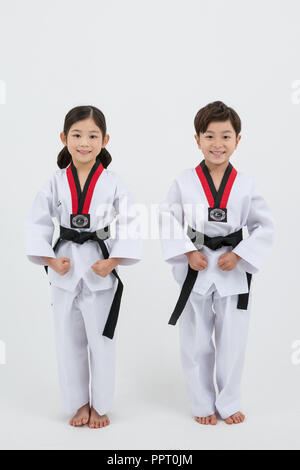 Kinder Bildung. Taekwondo, kleinen Jungen und Mädchen Praxis Kampfkunst in weißen Hintergrund 235 Stockfoto