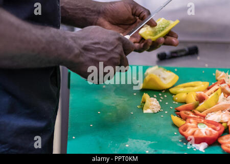 Junge, politischer Flüchtling, entkam aus Afrika mit dem Boot. Dort Anerkennung und Arbeit in Europa. Veganes Restaurant, Koch Auszubildender, raw-Diät, Lieferservice Stockfoto