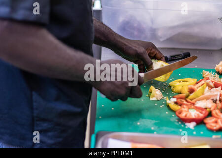 Junge, politischer Flüchtling, entkam aus Afrika mit dem Boot. Dort Anerkennung und Arbeit in Europa. Veganes Restaurant, Koch Auszubildender, raw-Diät, Lieferservice Stockfoto