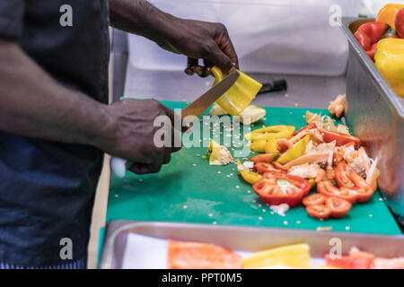 Junge, politischer Flüchtling, entkam aus Afrika mit dem Boot. Dort Anerkennung und Arbeit in Europa. Veganes Restaurant, Koch Auszubildender, raw-Diät, Lieferservice Stockfoto