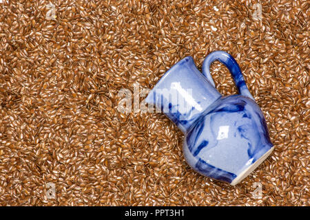 Viele von ganzen frischen braunen Leinsamen mit blauem Glas flatlay isoliert Stockfoto
