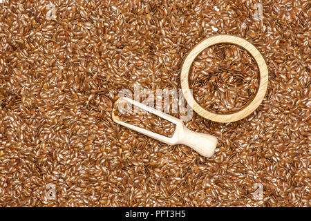 Viele von ganzen frischen braunen Leinsamen in eine Schaufel mit Houten flatlay isoliert Stockfoto