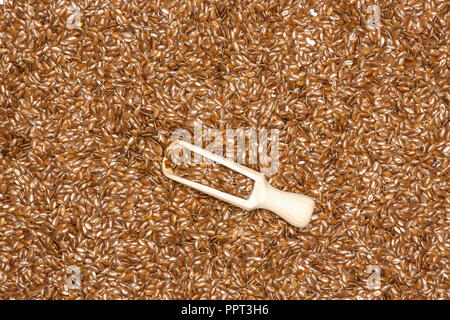 Viele von ganzen frischen braunen Leinsamen mit Holz- schaufel flatlay isoliert Stockfoto
