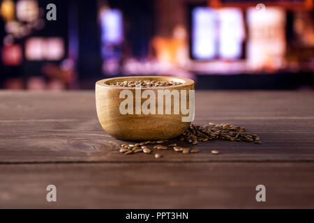 Viele von ganzen frischen braunen Leinsamen mit Holzschale mit Restaurant im Hintergrund Stockfoto
