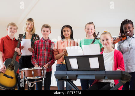 Portrait von Schülern in der Schule spielen Orchester mit Lehrer Stockfoto