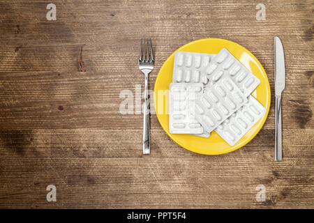 Pillen, Drogen, Tabletten, pharmazeutische auf Platte mit Messer und Gabel Stockfoto