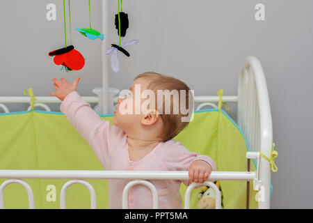 Das Kind berührt Mobile hängenden Filz Spielzeug Tier Stockfoto