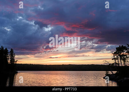 Lila Wolken und Silhouetten ar Sonnenuntergang auf Agnes See in Quetico Provincial Park in Ontario Stockfoto