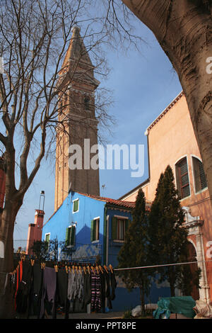 Der schiefe Campanile der Chiesa di San Martino, Burano, Venedig, Italien, mit Waschmaschine heraus hängen an einem sonnigen Wintertag zu trocknen Stockfoto