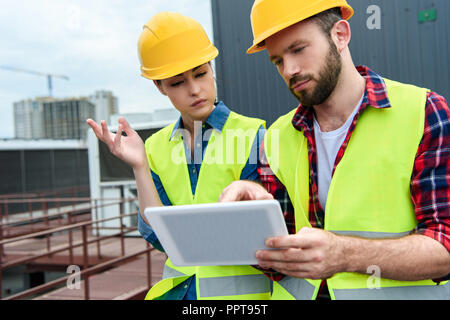 Nachdenklich Architekten in Helme mit digitalen Tablet Stockfoto