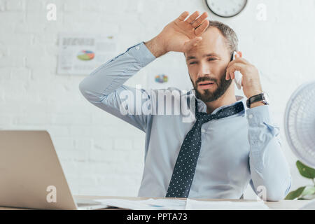 Verschwitzte Geschäftsmann sprechen auf Smartphone und die Arbeit in einem Büro erschöpft Stockfoto