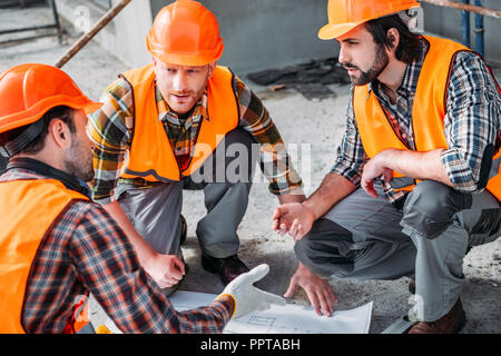 Nahaufnahme der Gruppe zuversichtlich Bauherren in Gespräch über Gebäude planen Stockfoto