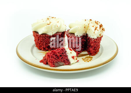 Zwei Redvelvet Cupcakes auf einer Platte und auch auf einem weißen Hintergrund. Die Scheibe an der Front ist im Fokus. Gutes image für konditor oder Bäcker. Stockfoto