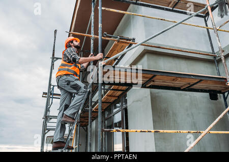 Stattliche builder Klettern auf Gerüsten an der Baustelle Stockfoto