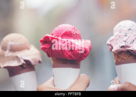 Woman's Hände, die schmelzenden Eis Waffel Kegel in die Hände auf Sommer Licht Stockfoto