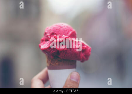 Woman's Hände, die schmelzenden Eis Waffel Kegel in die Hände auf Sommer Licht Stockfoto