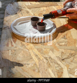 Ginja de Obidos, traditionelle Sauerkirschen Likör, in kleinen Schalen aus Schokolade serviert. Stockfoto