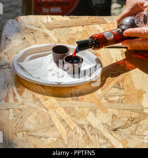 Ginja de Obidos, traditionelle Sauerkirschen Likör, in kleinen Schalen aus Schokolade serviert. Stockfoto