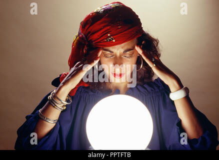 Junge Frau Konzentration über Crystal Ball, USA Stockfoto