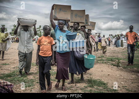 Uganda. 7. Mai, 2018. Der Südsudanesische weibliche Flüchtlinge gesehen, die Palmöl auf ihre Köpfe, wie Sie diese Versorgung mit Nahrungsmitteln durch das Welternährungsprogramm gegeben wurden. Die Bidi Bidi Flüchtling Siedlung im Norden Ugandas in der Nähe der sudanesischen Grenze ist derzeit das größte Flüchtlingslager der Welt, Hosting über 250.000 sudanesische Flüchtlinge im Süden des Konflikts. Das Welternährungsprogramm ist die Bereitstellung von monatlichen grundlegende Lebensmittel für die Flüchtlinge in der Siedlung. Credit: Alda Tsang/SOPA Images/ZUMA Draht/Alamy leben Nachrichten Stockfoto