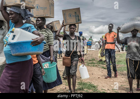 Uganda. 7. Mai, 2018. Der Südsudanesische weibliche Flüchtlinge gesehen, die Palmöl auf ihre Köpfe, wie Sie diese Versorgung mit Nahrungsmitteln durch das Welternährungsprogramm gegeben wurden. Die Bidi Bidi Flüchtling Siedlung im Norden Ugandas in der Nähe der sudanesischen Grenze ist derzeit das größte Flüchtlingslager der Welt, Hosting über 250.000 sudanesische Flüchtlinge im Süden des Konflikts. Das Welternährungsprogramm ist die Bereitstellung von monatlichen grundlegende Lebensmittel für die Flüchtlinge in der Siedlung. Credit: Alda Tsang/SOPA Images/ZUMA Draht/Alamy leben Nachrichten Stockfoto