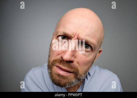 Kahle reife Kerl in grau casual Shirt entdecken versteckte Kamera. Stockfoto