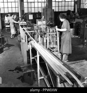 1950, historische, weibliche Arbeitnehmer in Overalls in in der Fabrik arbeiten, Wald Rd, Walthamstow, London, England, UK. Stockfoto
